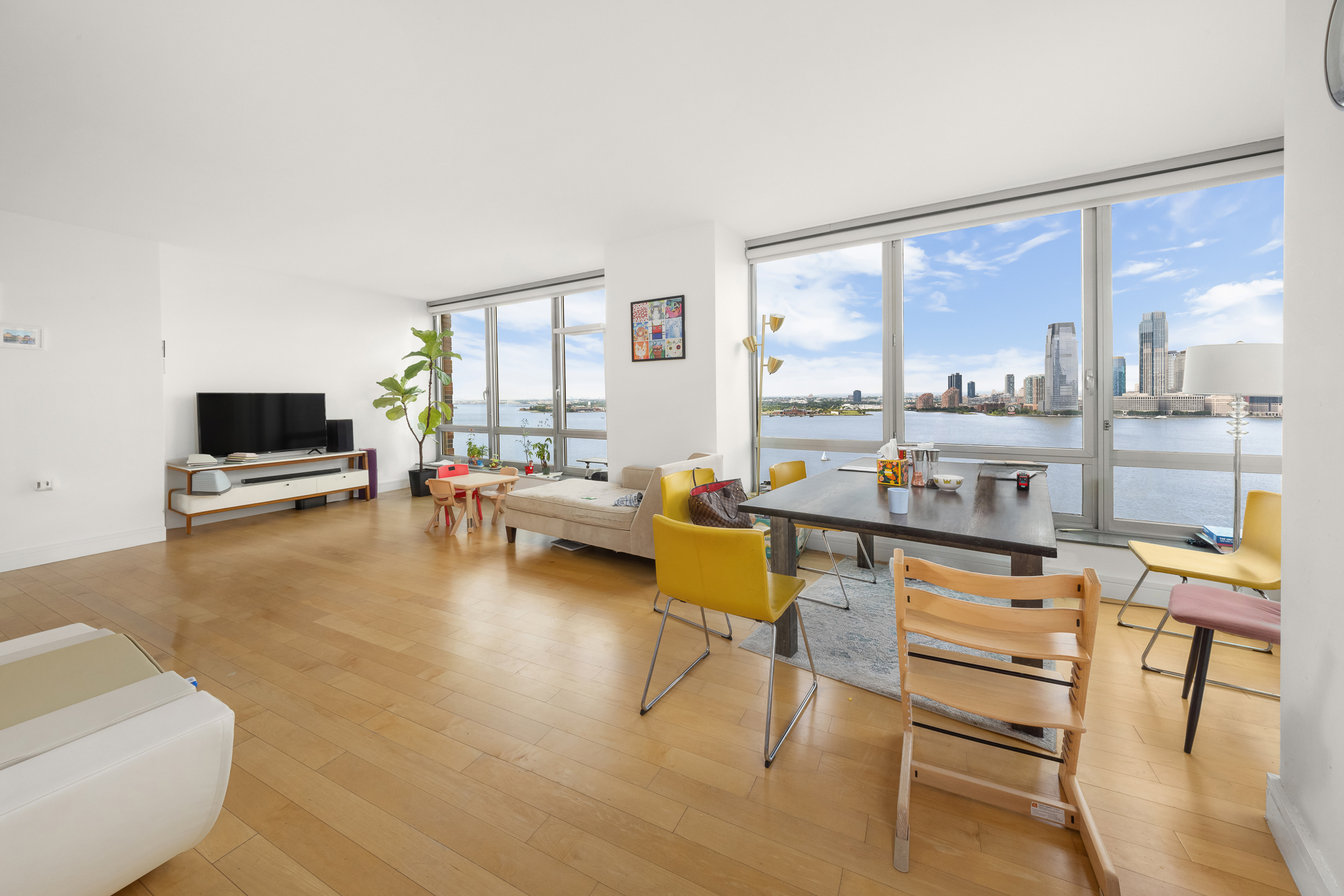 30 West Street, Unit 19A Manhattan, NY 10004 - Photo 3 of 12 a living room with furniture and a large window