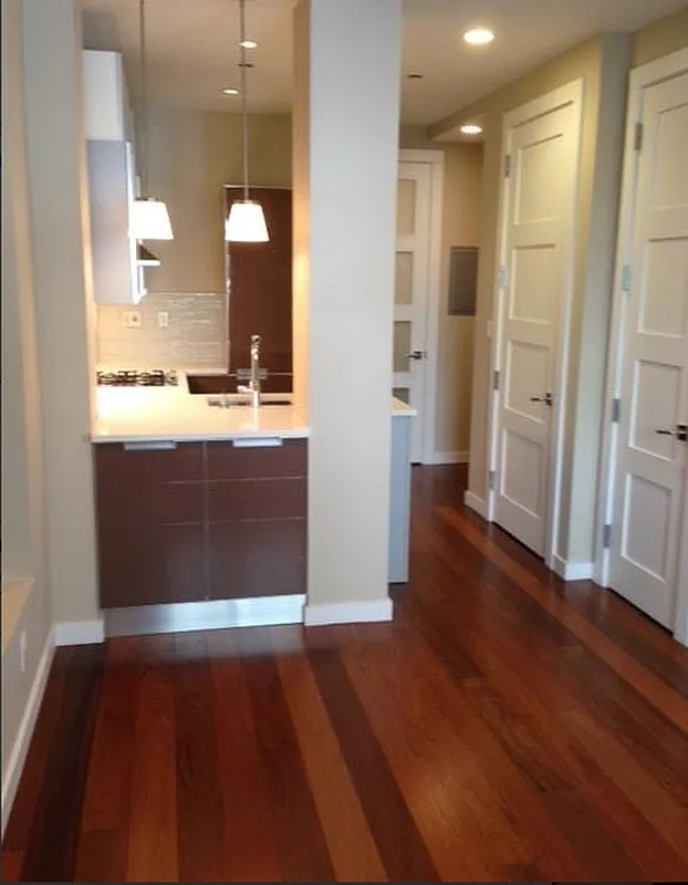 148 East 19th Street, Unit 2D Manhattan, NY 10003 - Photo 3 of 16 an empty room with wooden floor and windows