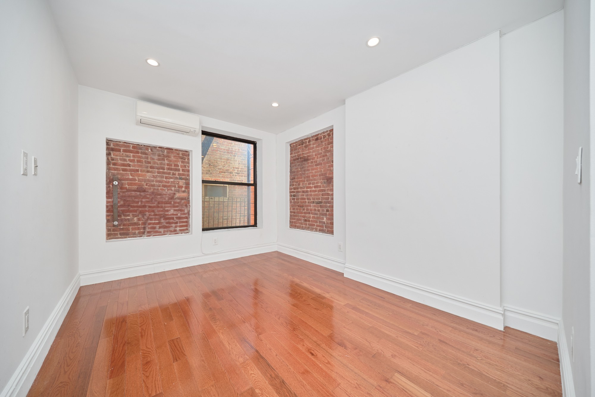 941 Columbus Avenue, Unit 1A Manhattan, NY 10025 - Photo 6 of 14 a view of an empty room with wooden floor and a window