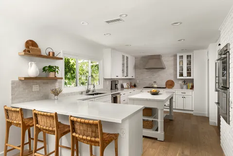 a kitchen with a table chairs refrigerator and cabinets