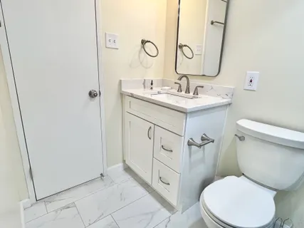 a bathroom with a toilet sink and mirror
