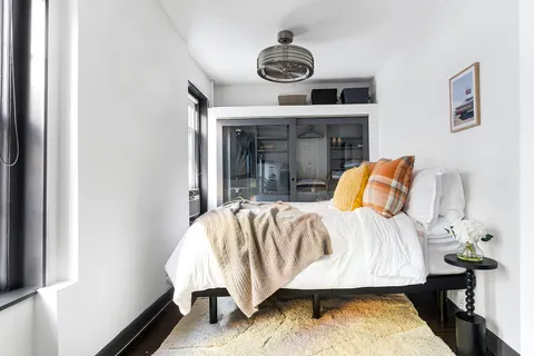 a bed sitting in a bedroom next to a window