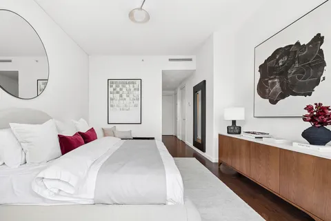 a bedroom with a large bed and a mirror