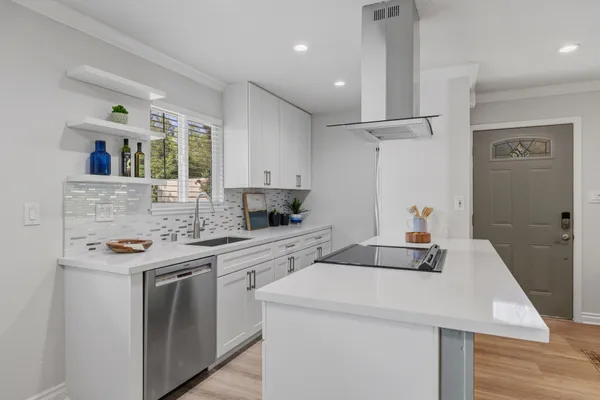 a kitchen with a sink a stove and cabinets