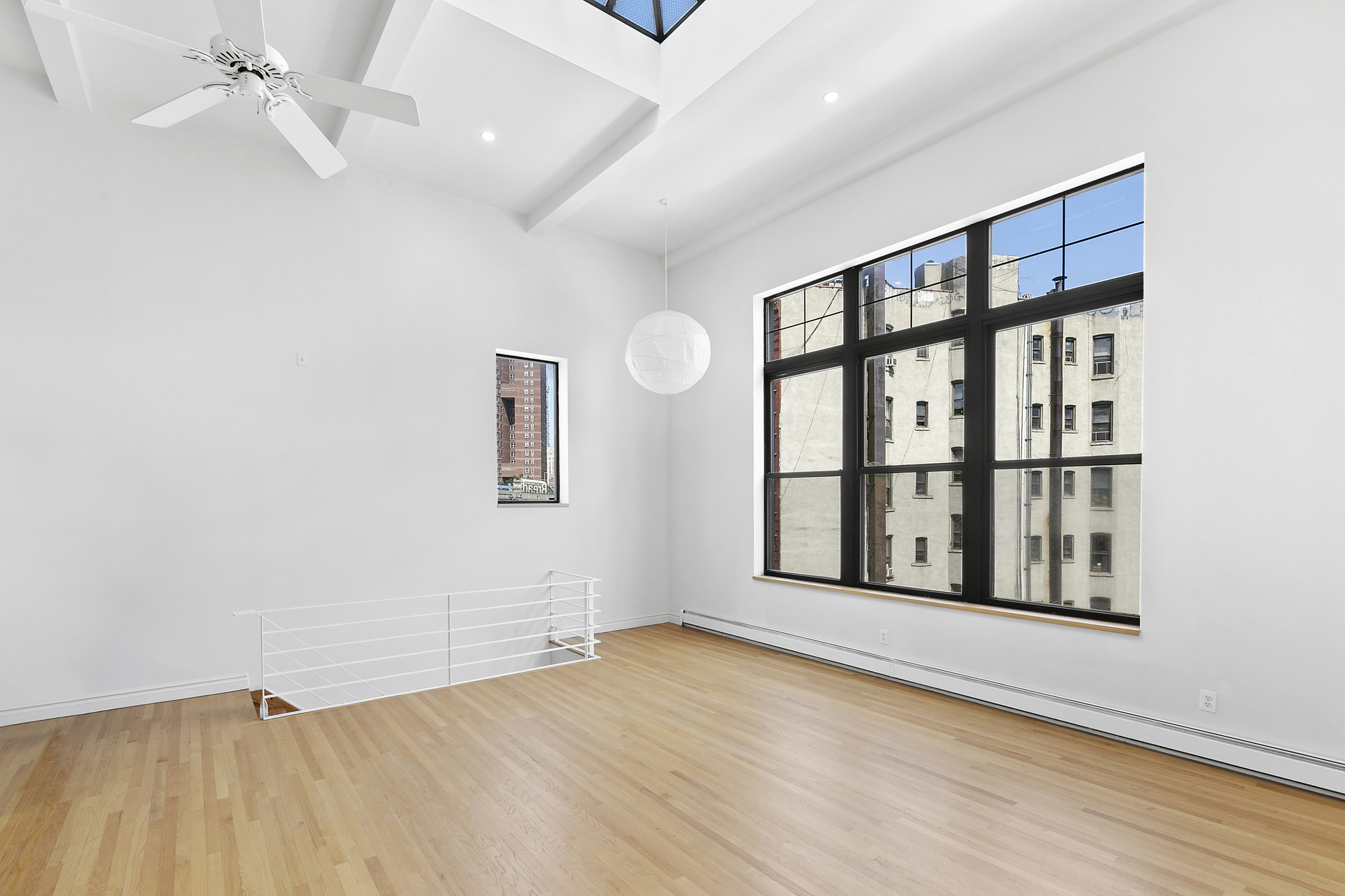 85 Division Street, Unit 4 Manhattan, NY 10002 - Photo 8 of 22 an empty room with wooden floor and windows