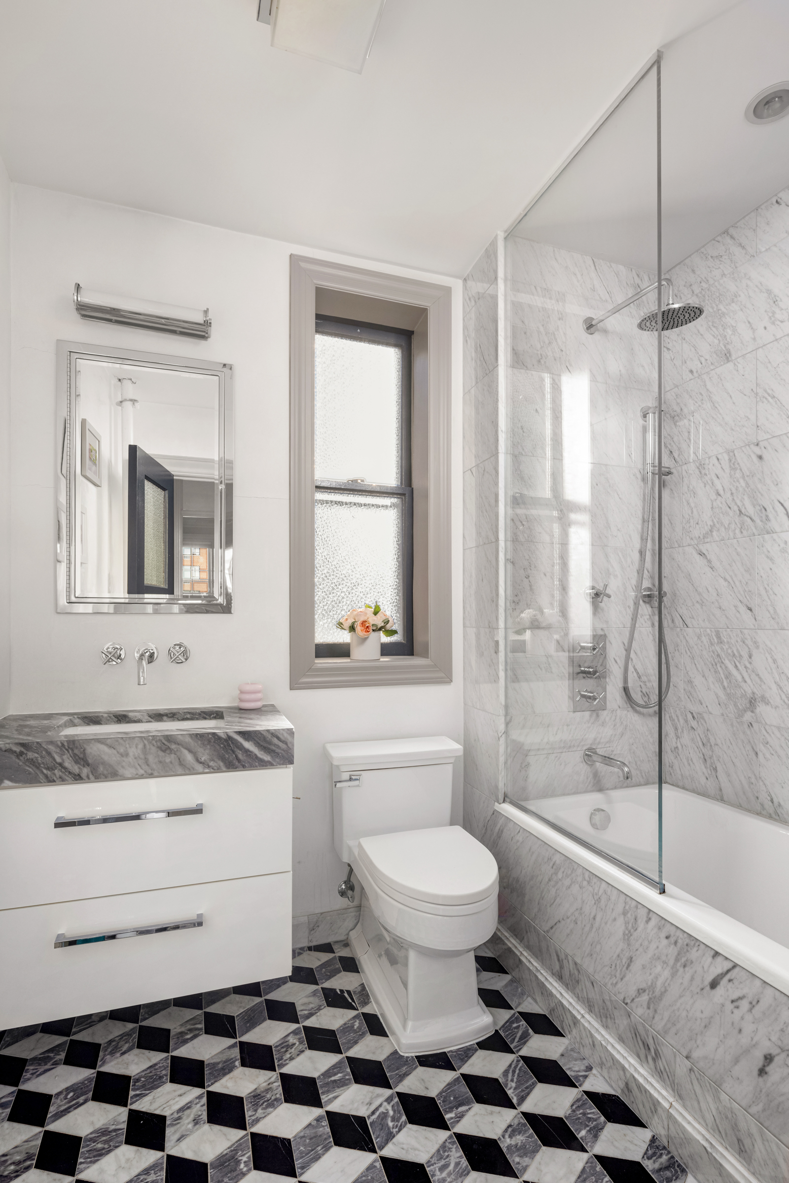 15 West 11th Street, Unit 9A Manhattan, NY 10011 - Photo 6 of 9 a bathroom with a sink toilet a mirror and shower