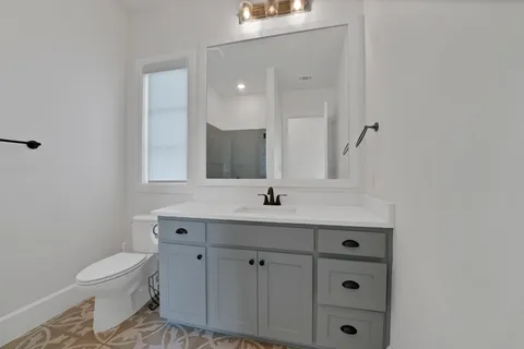 a bathroom with a toilet sink and mirror