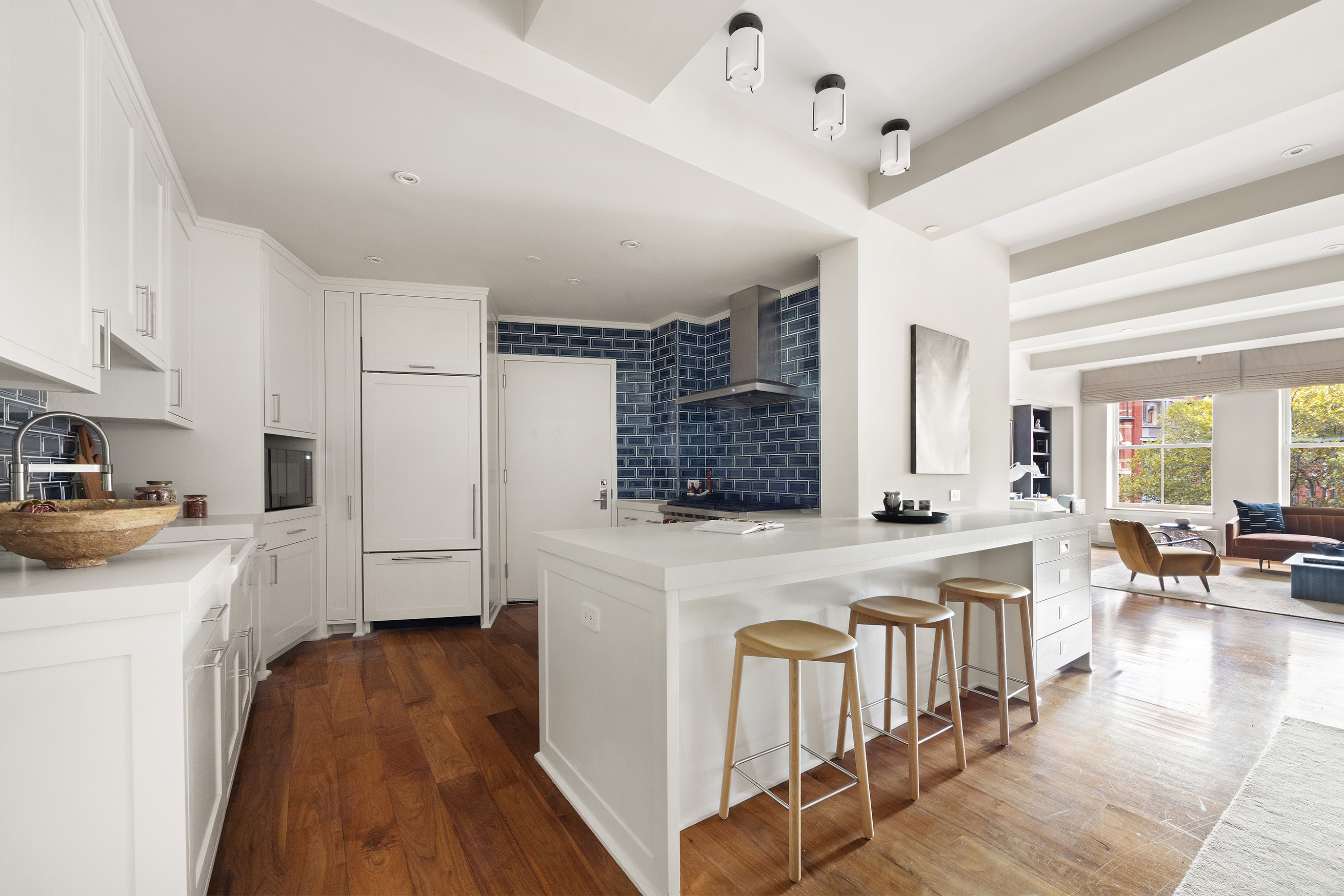 161 Duane Street, Unit 4B Manhattan, NY 10013 - Photo 6 of 16 a kitchen with a stove a refrigerator a oven a sink dishwasher and white cabinets with wooden floor