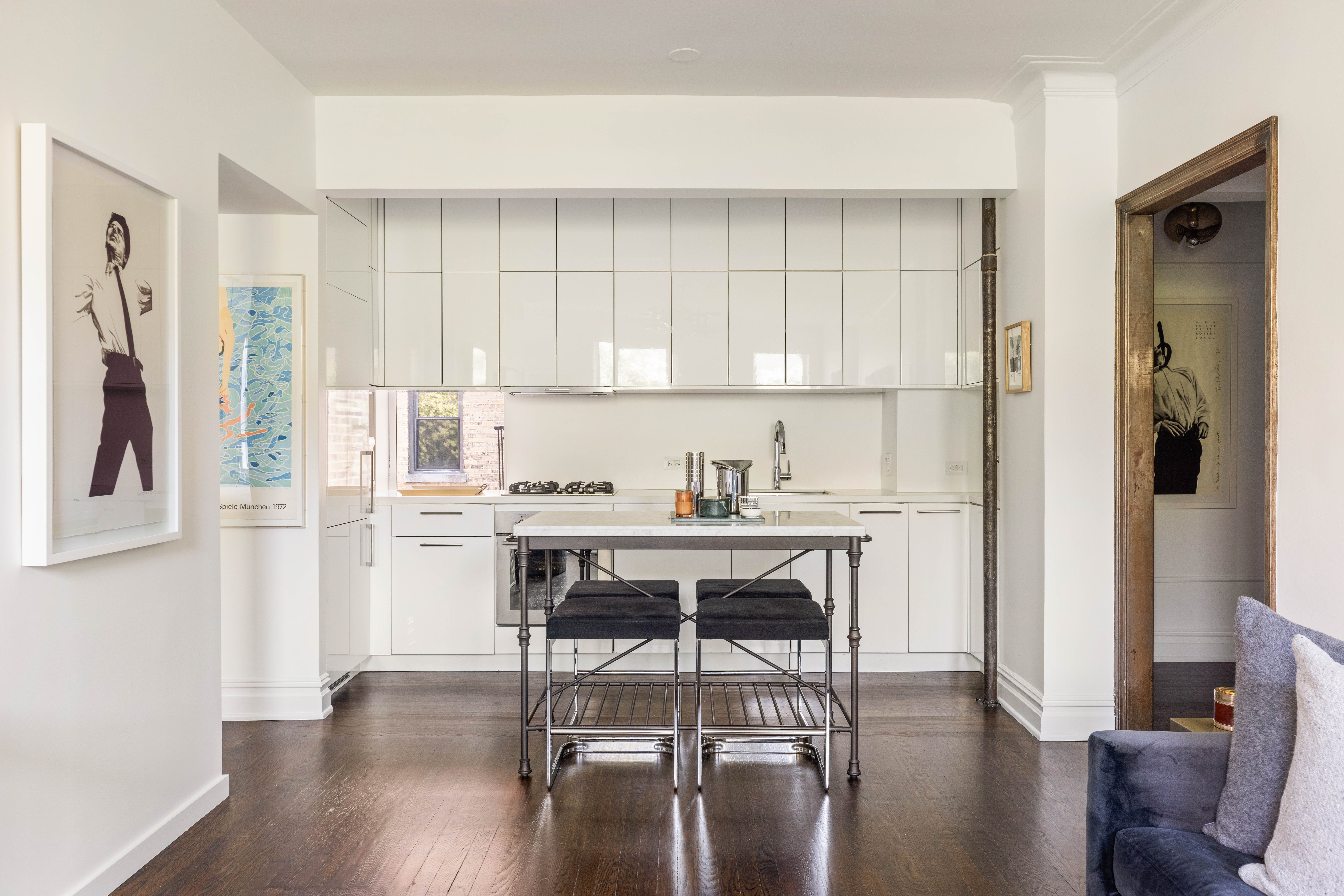 253 West 16th Street, Unit 5C Manhattan, NY 10011 - Photo 3 of 11 a kitchen with stainless steel appliances kitchen island wooden floors and white cabinets