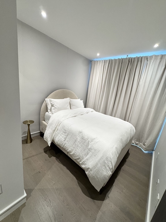 55 Lagrange Street, Unit 304 Boston, MA 02111 - Photo 11 of 15 a large bed sitting in a bedroom next to a window