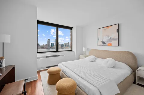 a bedroom with a bed and a large window