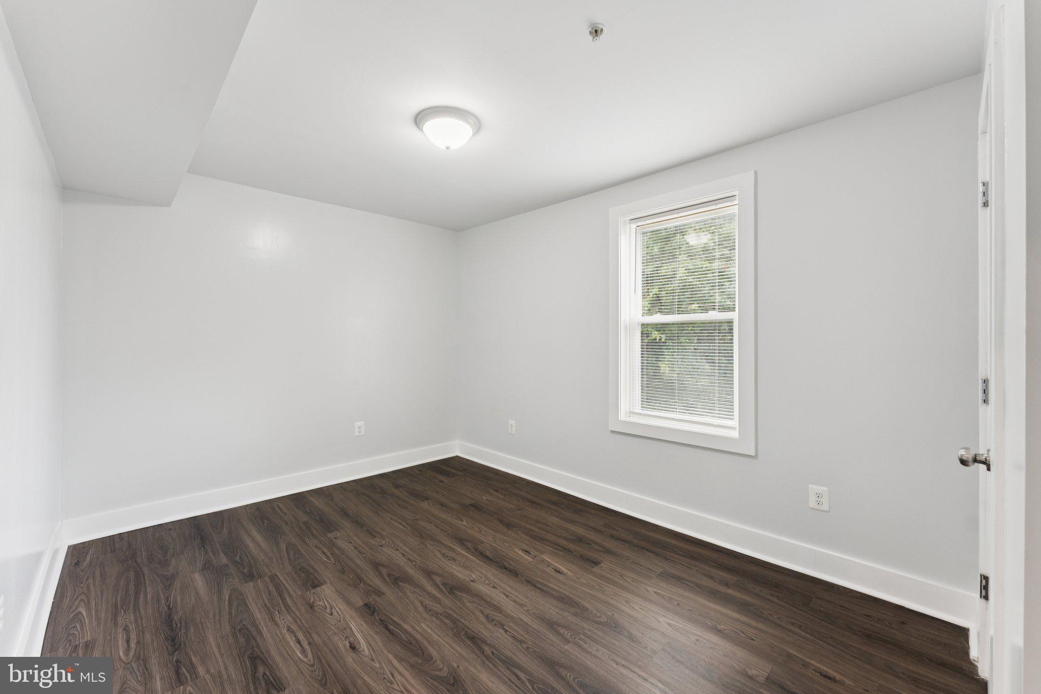 2822 28th Street Southeast Washington, DC 20020 - Photo 13 of 57 an empty room with wooden floor and windows