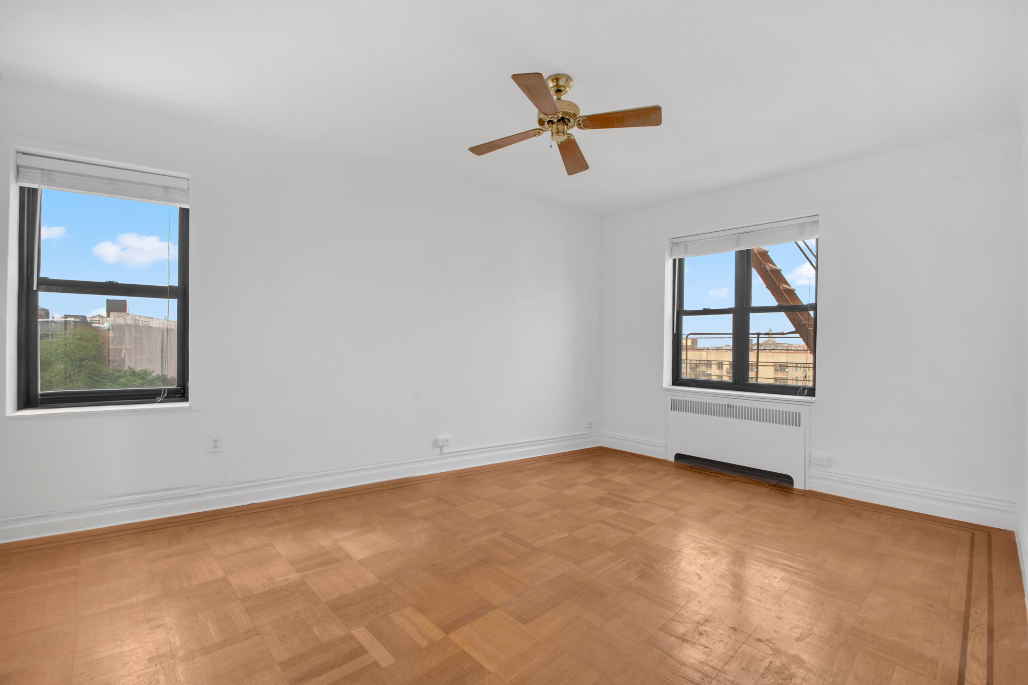 200 Pinehurst Avenue, Unit 5C Manhattan, NY 10033 - Photo 12 of 17 an empty room with windows and fan
