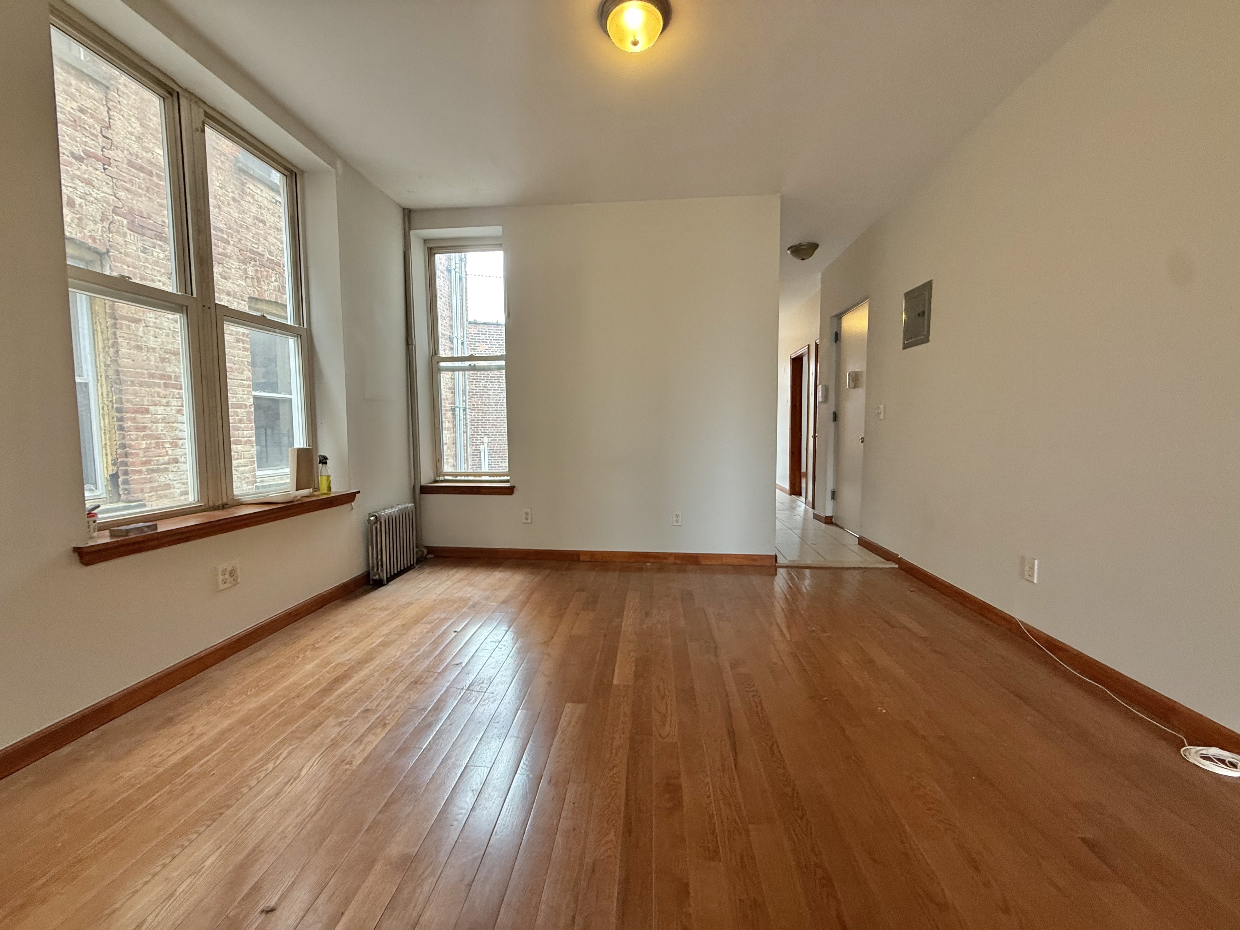 386 Prospect Place Brooklyn, NY 11238 - Photo 2 of 7 a view of an empty room with wooden floor and a window