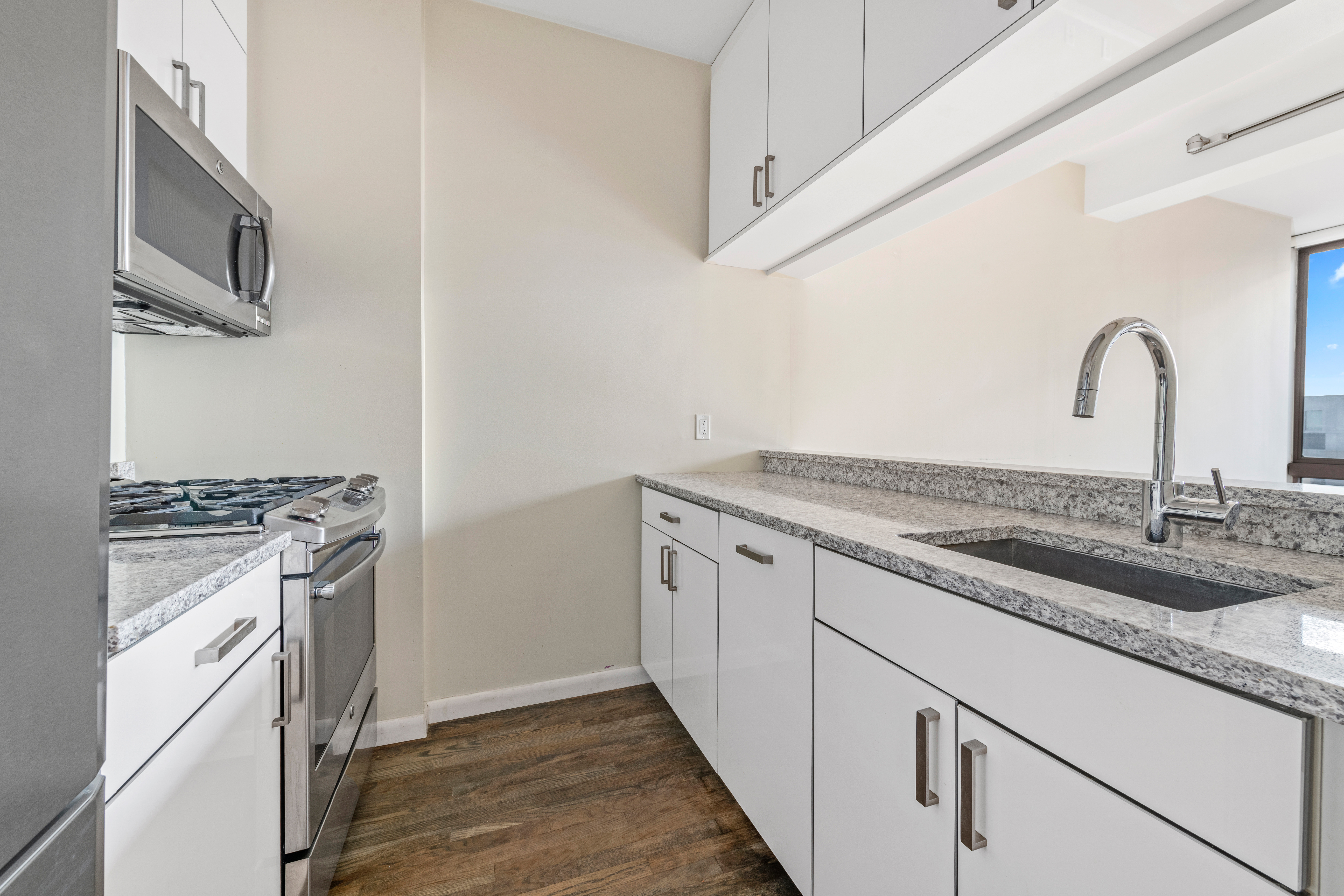 524 East 72nd Street, Unit 24A Manhattan, NY 10021 - Photo 5 of 12 a kitchen with stainless steel appliances granite countertop a stove and a sink with wooden cabinets