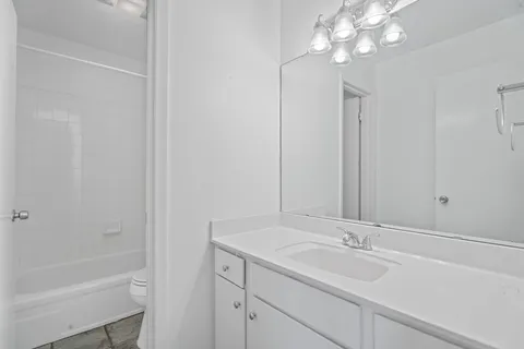 a bathroom with a sink a large mirror and a bathtub