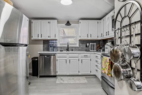 a kitchen with stainless steel appliances granite countertop a refrigerator and a stove top oven