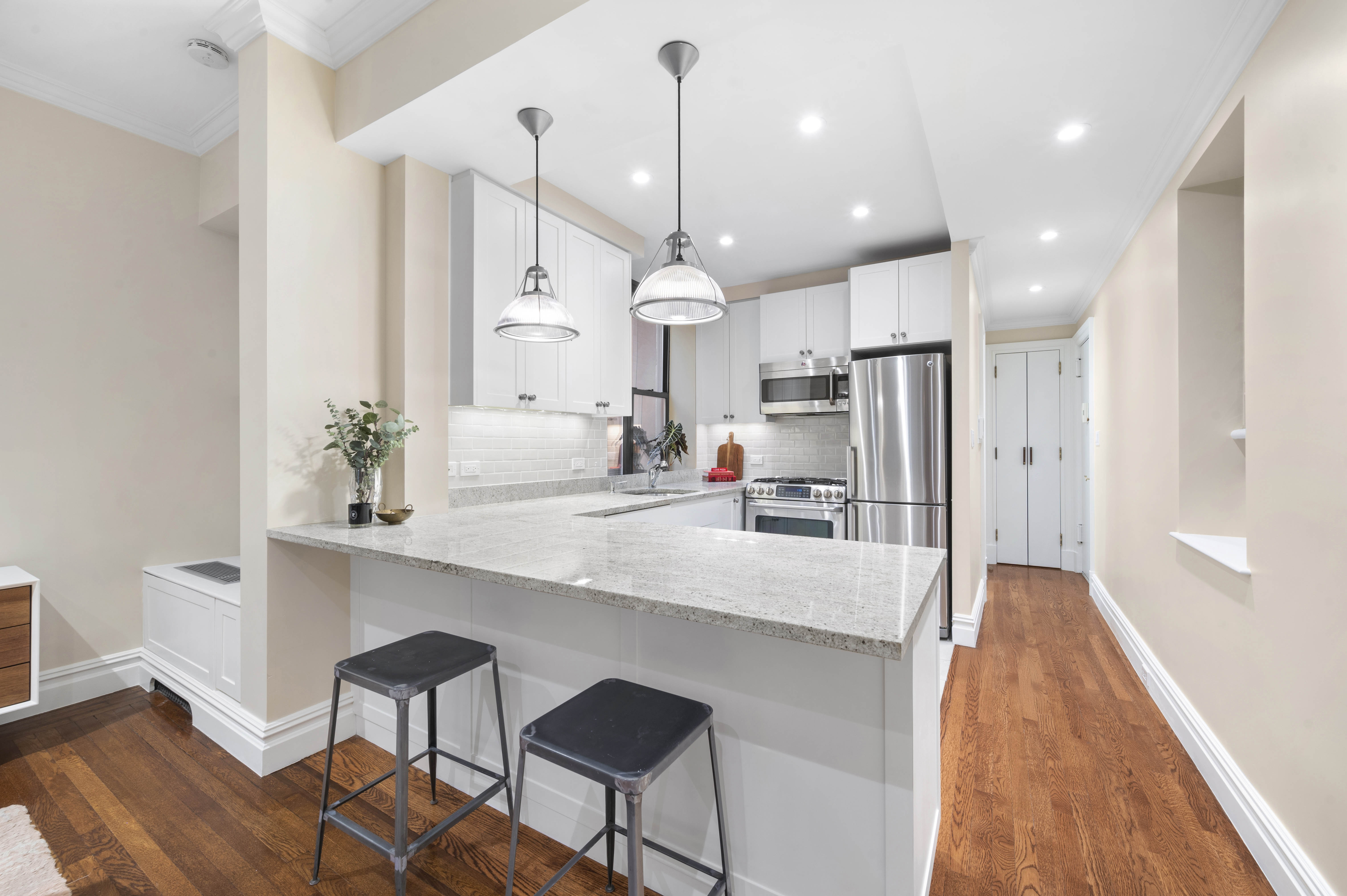 444 East 58th Street, Unit 1C Manhattan, NY 10022 - Photo 2 of 9 a large kitchen with kitchen island a island in the center