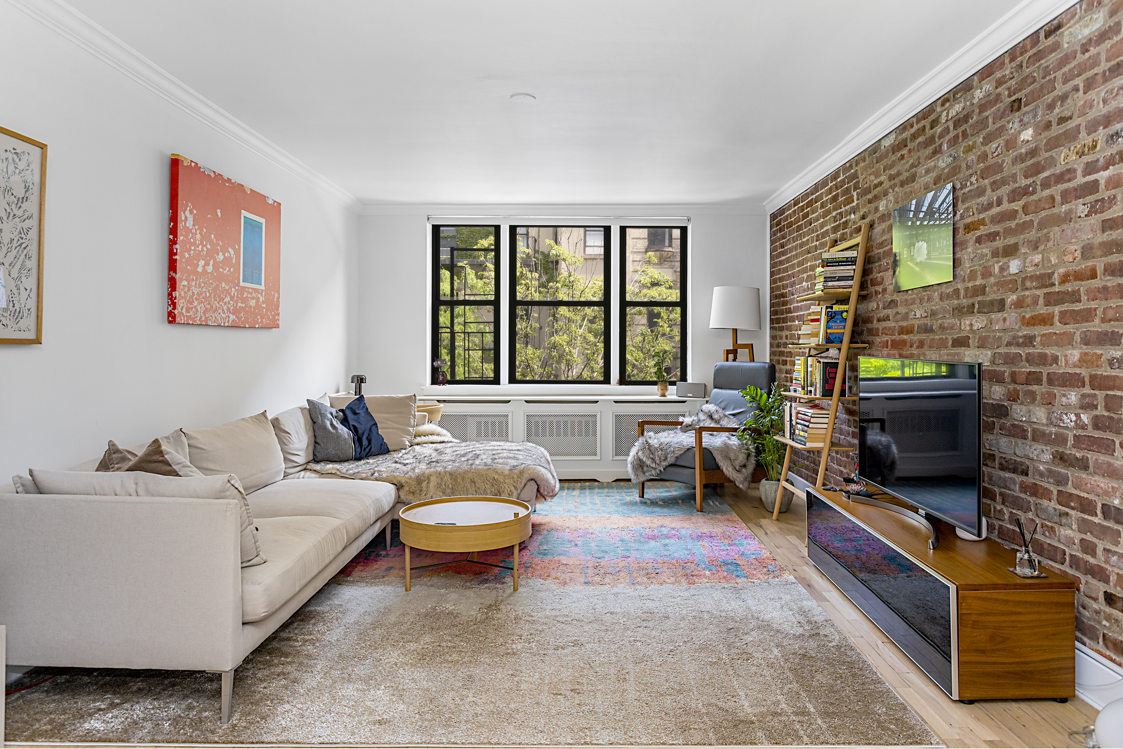 a living room with furniture a flat screen tv and a fireplace