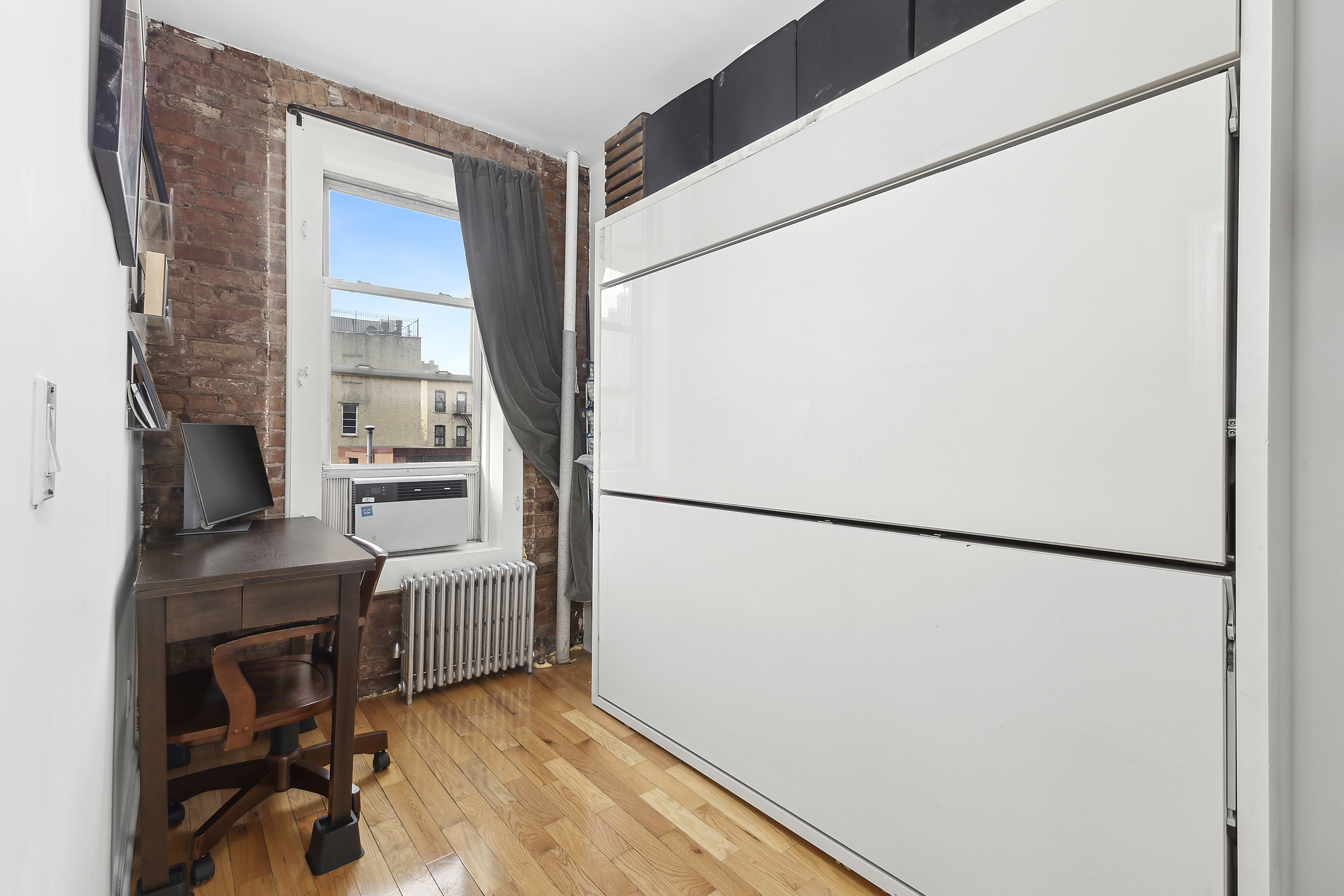 124 Thompson Street, Unit 21 Manhattan, NY 10012 - Photo 8 of 10 a view of kitchen with refrigerator and wooden floor