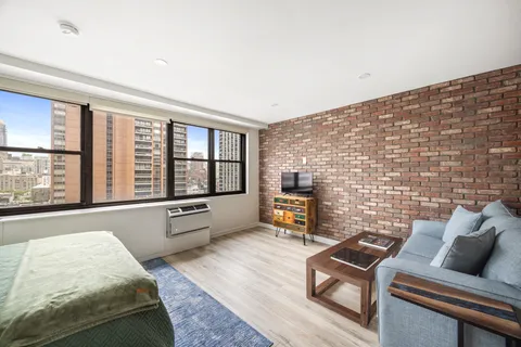 a living room with furniture and a floor to ceiling window