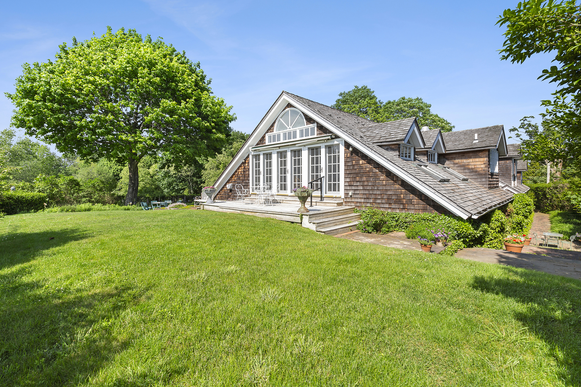 488 Ocean Road Bridgehampton, NY 11932 - Photo 18 of 21 a view of a house with a yard and potted plants
