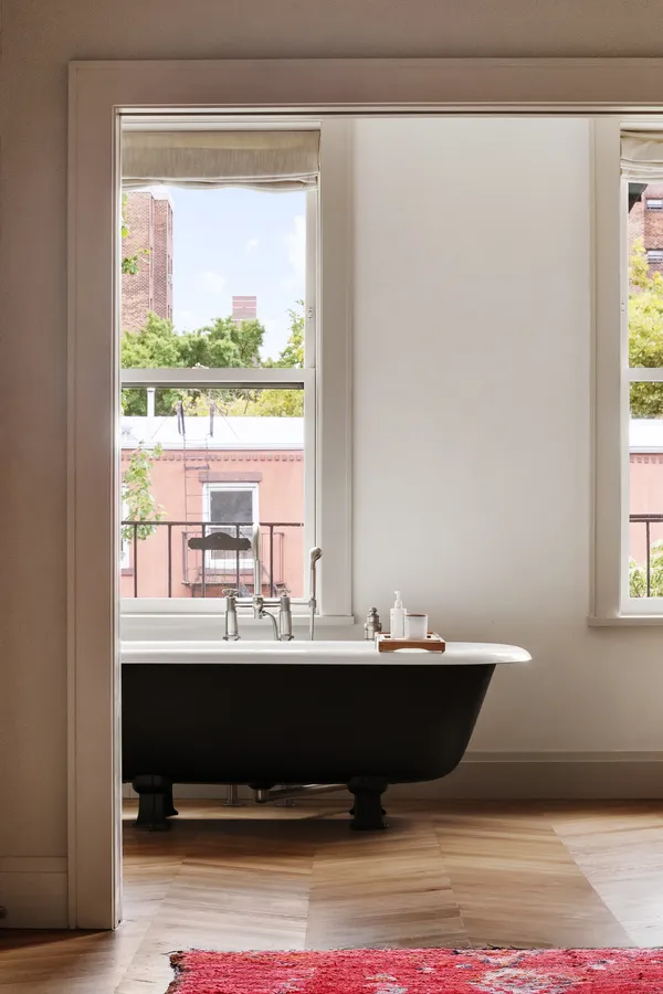 a living room with table mirror and a window