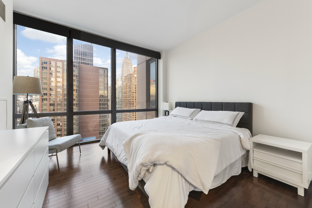 101 West 24th Street, Unit 26A Manhattan, NY 10011 - Photo 9 of 21 a bedroom with a bed and a large window