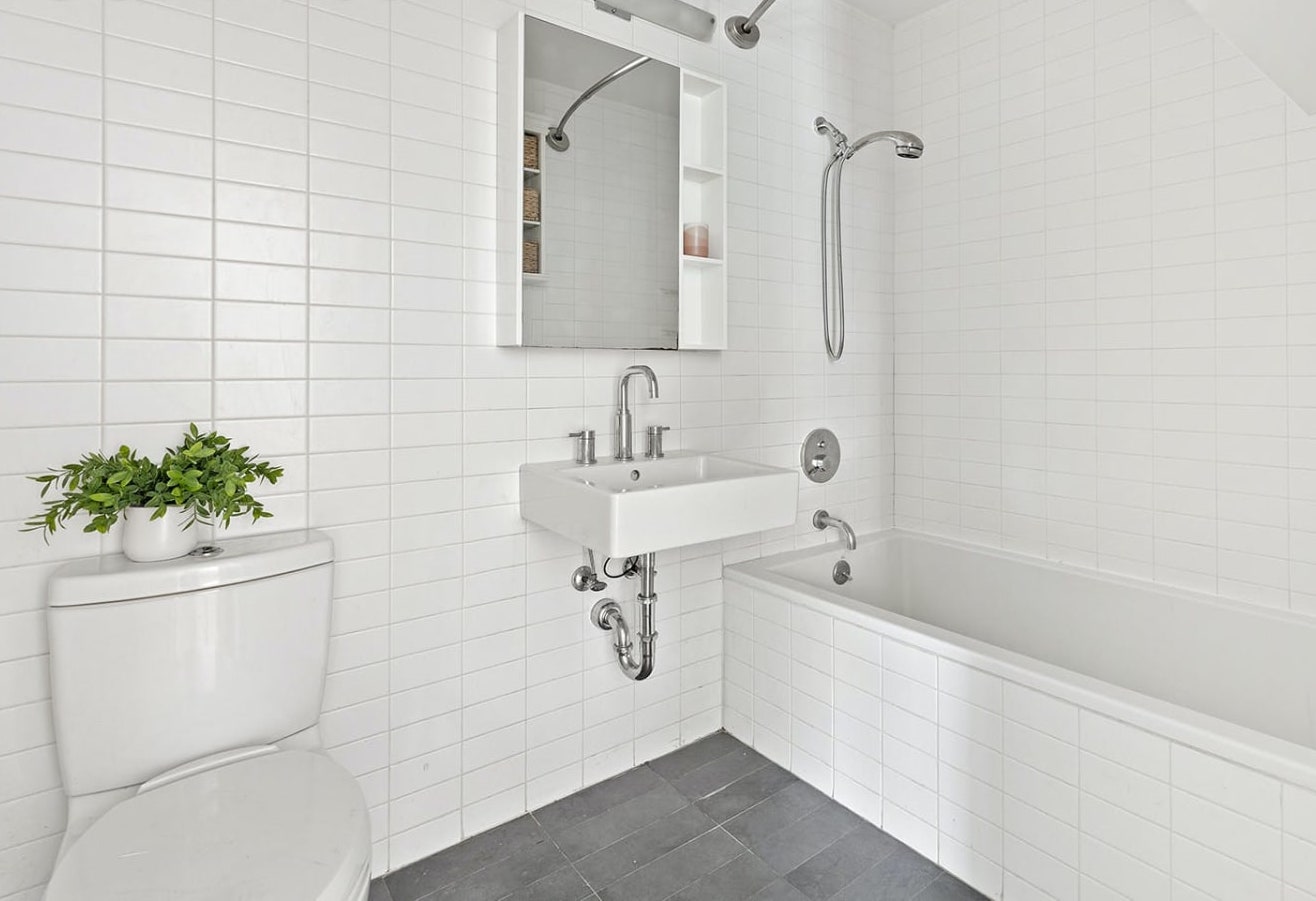 232 7th Street, Unit 2A Brooklyn, NY 11215 - Photo 4 of 8 a bathroom with a sink a bathtub and a potted plant