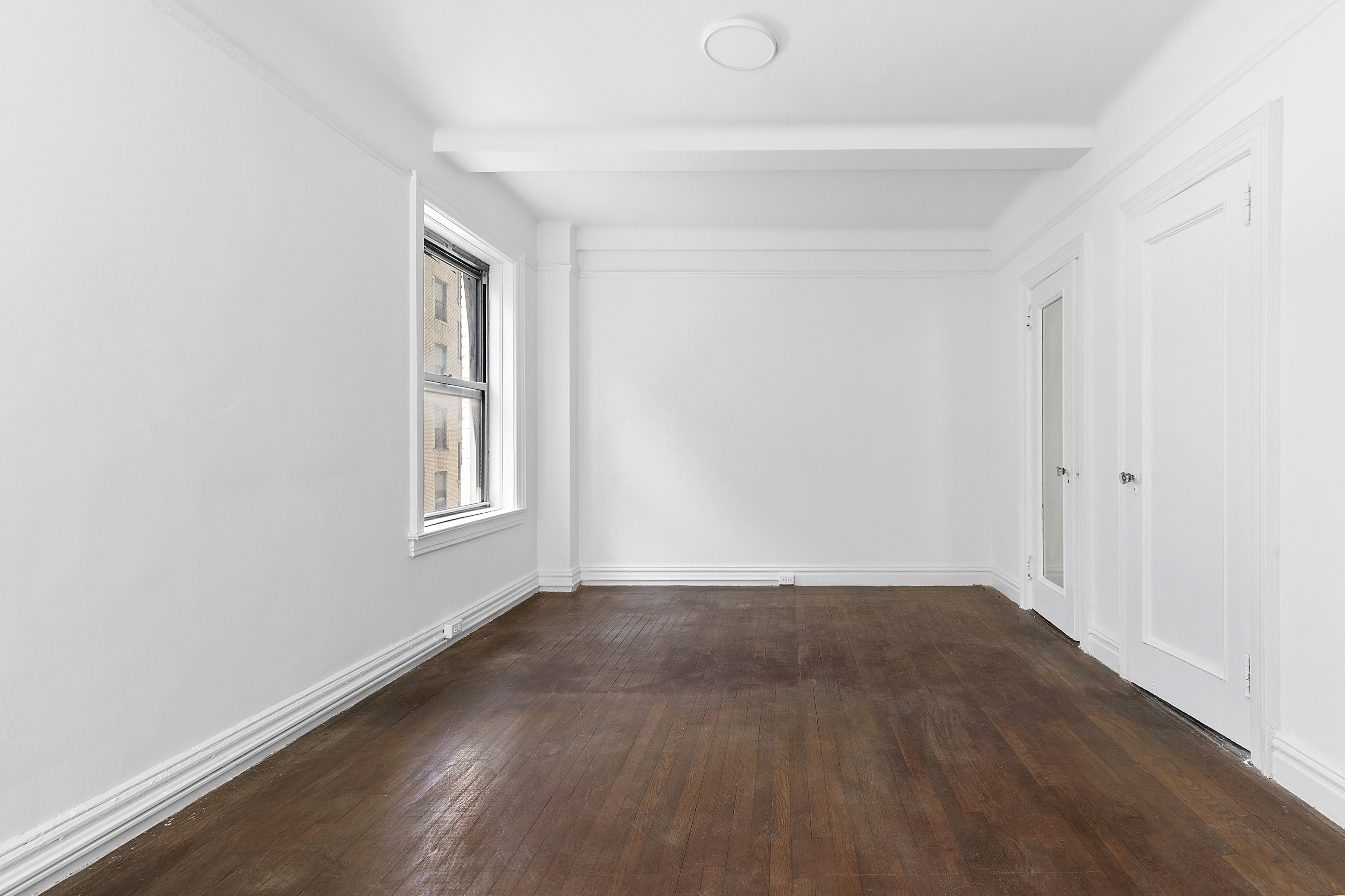 250 West 94th Street, Unit 8J Manhattan, NY 10025 - Photo 8 of 19 an empty room with wooden floor and windows