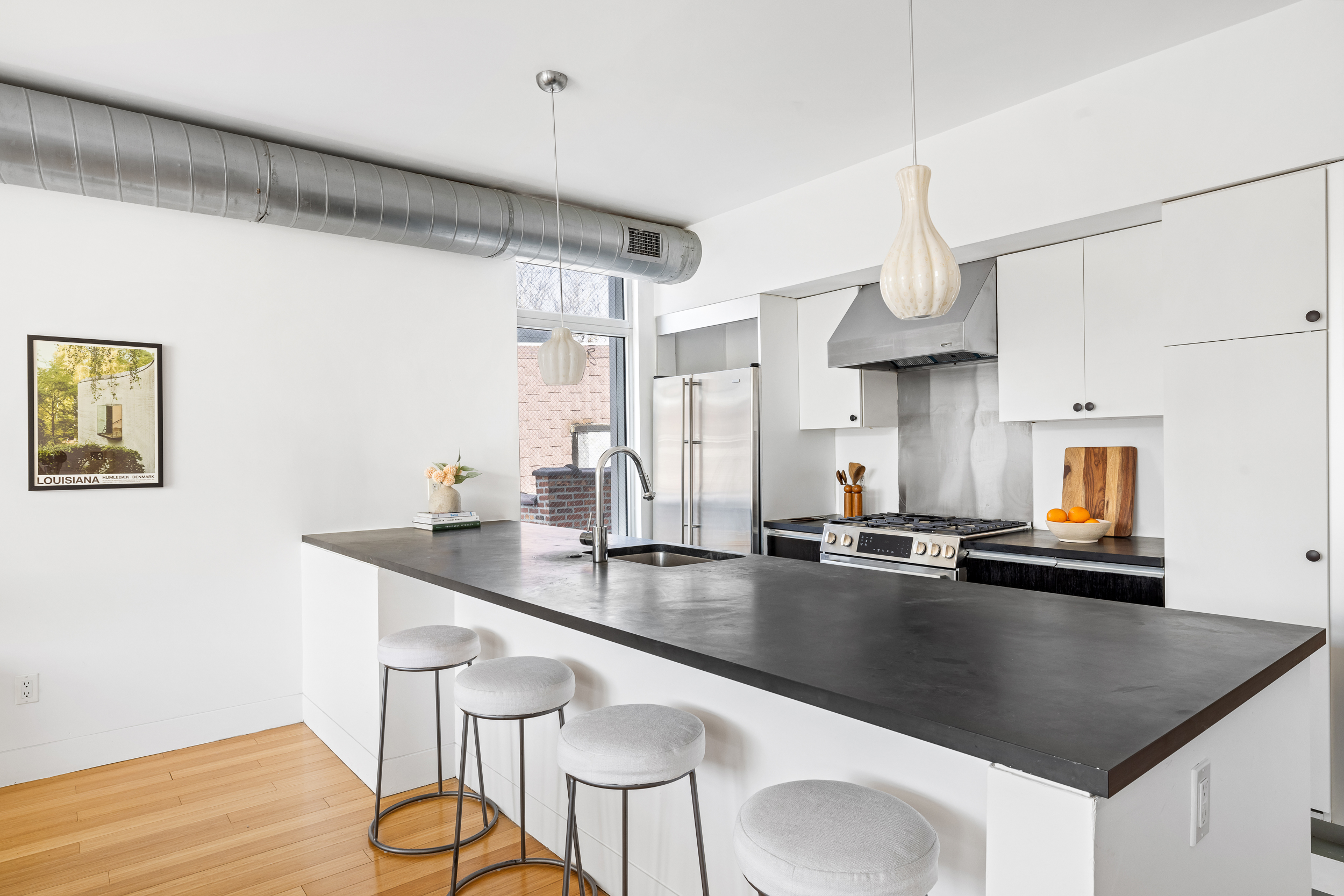 361 Manhattan Avenue, Unit 3AB Brooklyn, NY 11211 - Photo 4 of 21 a kitchen with stainless steel appliances granite countertop a sink a stove and chairs with wooden floor