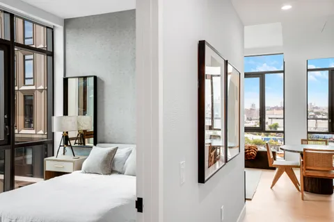 a bedroom with furniture and large windows