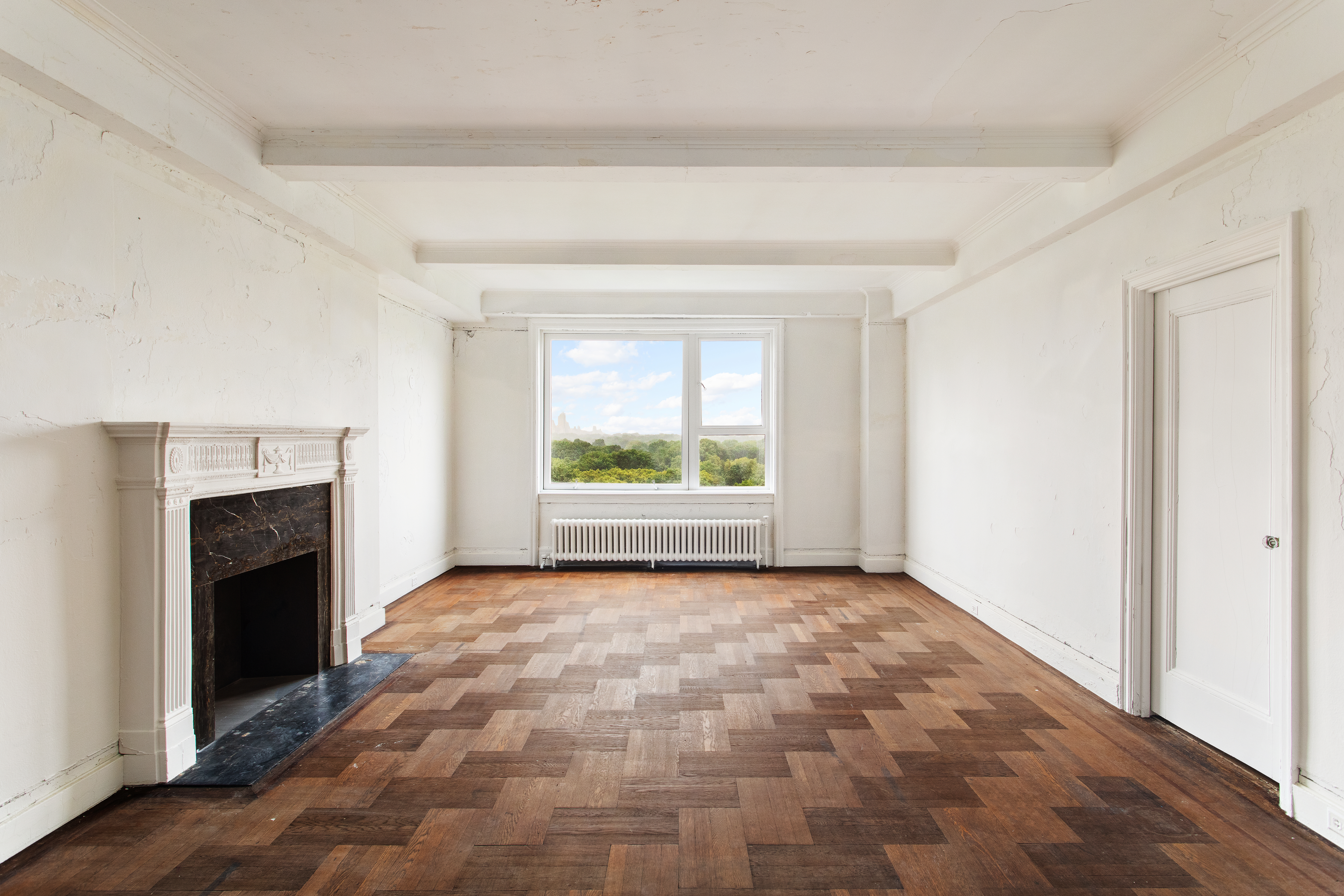an empty room with windows and a fireplace