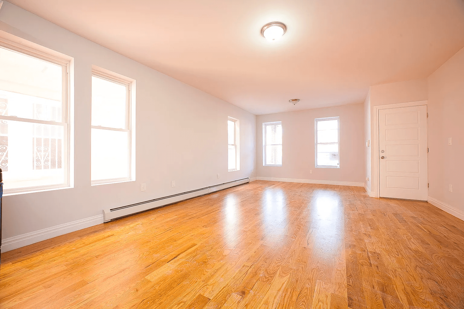 581 Van Siclen Avenue Brooklyn, NY 11207 - Photo 2 of 16 a view of an empty room with wooden floor and a window