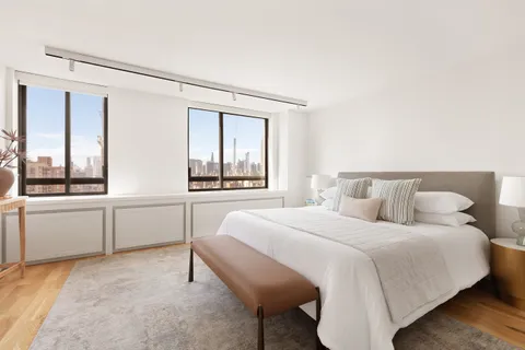 a bedroom with a bed and a large window