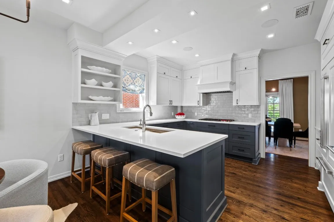 a kitchen with granite countertop a stove a sink and a refrigerator