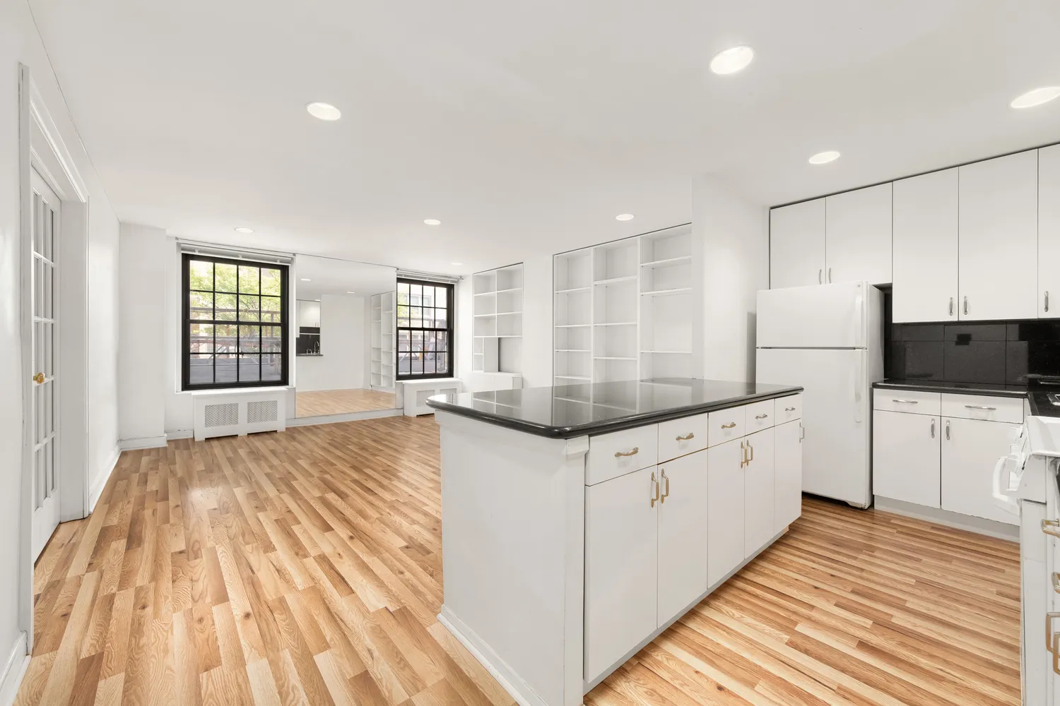 a kitchen with granite countertop a sink and dishwasher a stove top oven with wooden floor