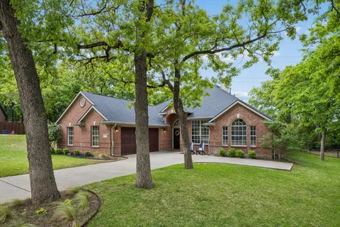 a front view of a house with a yard and green space