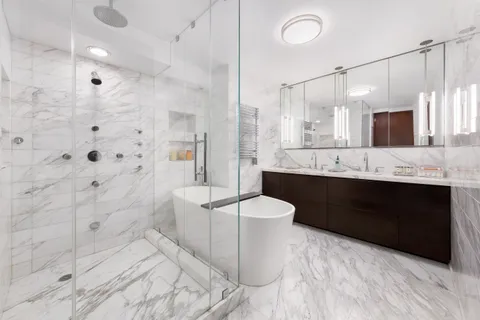 a bathroom with a double vanity sink toilet mirror and bathtub