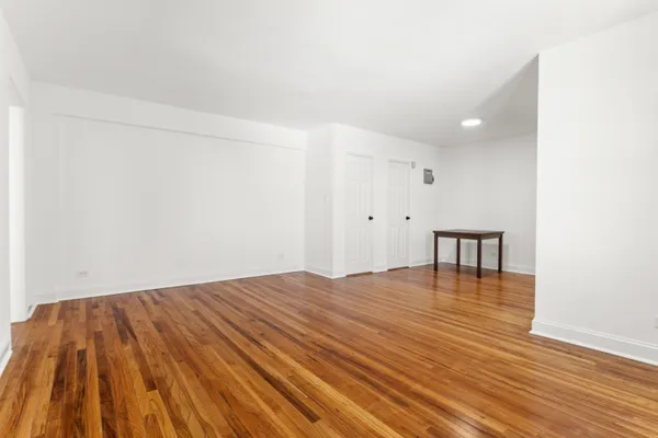 a view of empty room with wooden floor