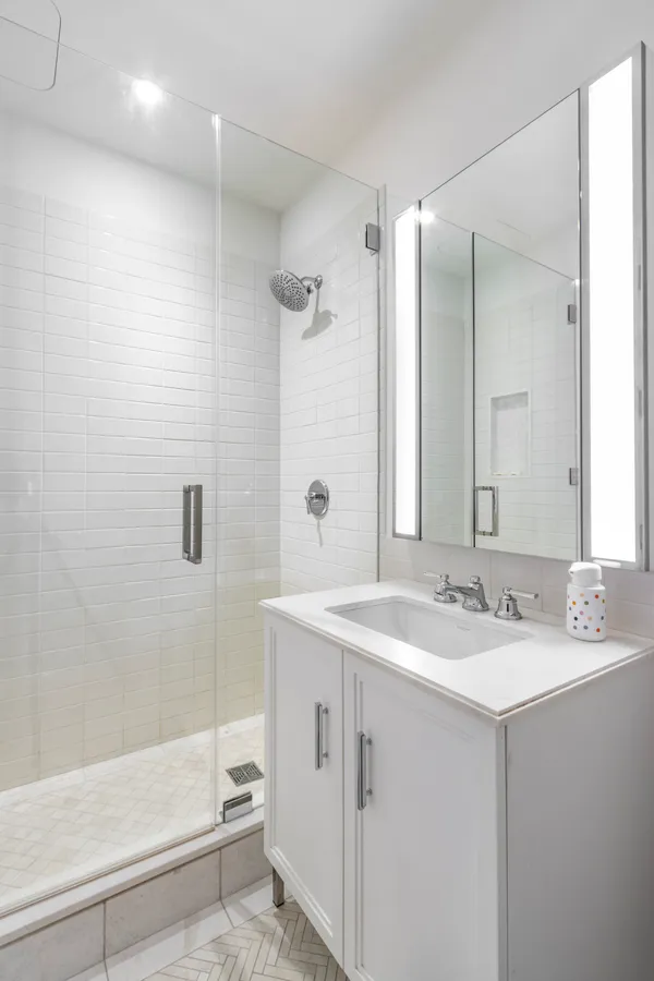 a bathroom with a sink double vanity mirror and a bathtub