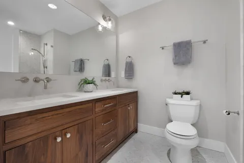 a bathroom with a toilet sink and mirror