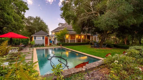 a view of a house with swimming pool and sitting area
