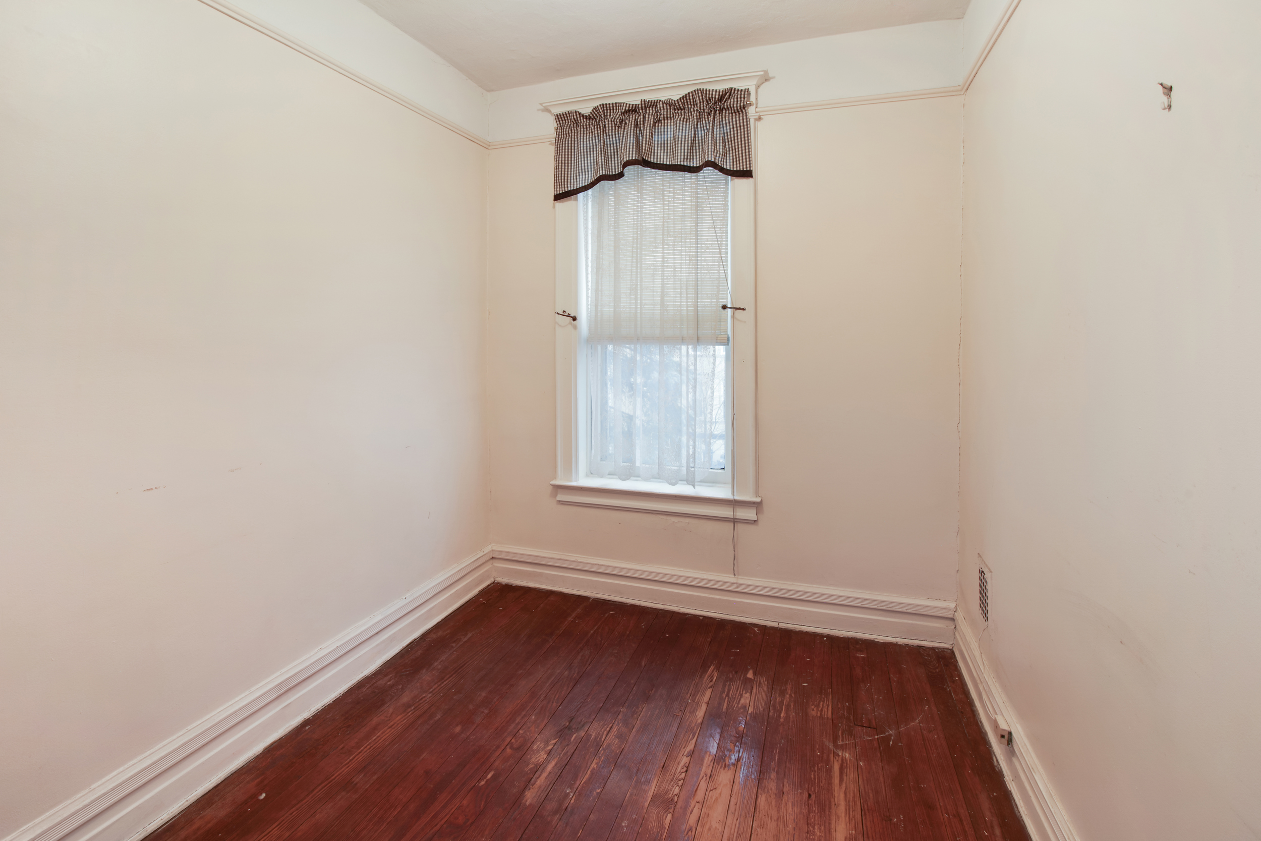 425 81st Street Brooklyn, NY 11209 - Photo 9 of 13 a view of an empty room with wooden floor and a window
