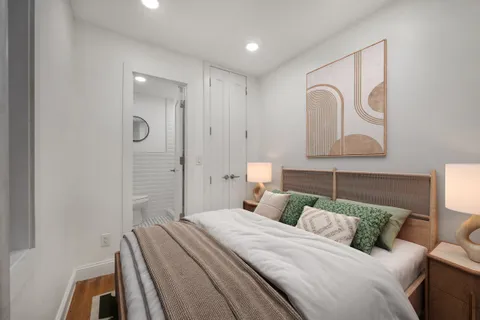 a bedroom with a bed and a potted plant
