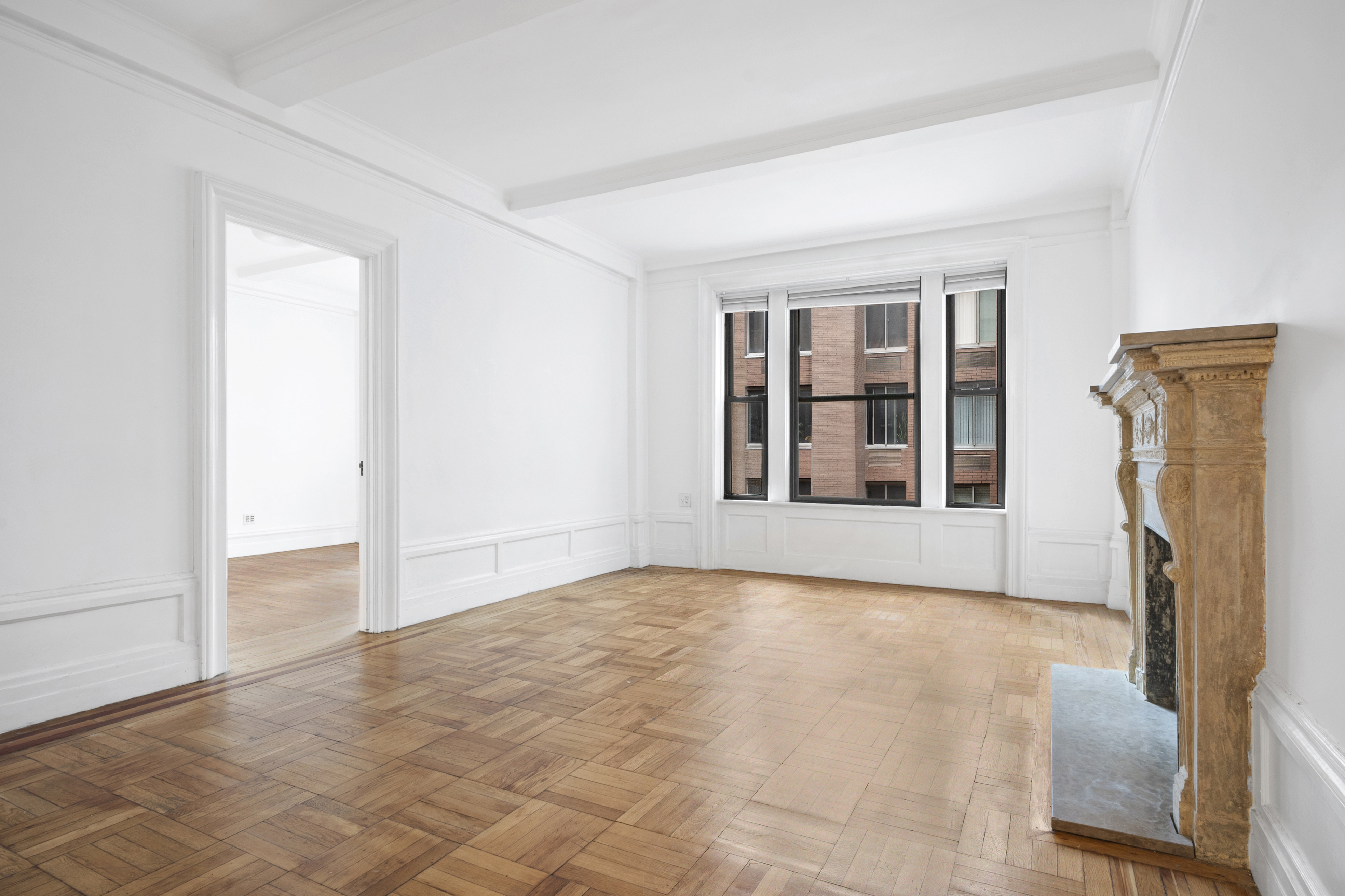 146 East 49th Street, Unit 6CD Manhattan, NY 10017 - Photo 5 of 12 a view of an empty room with a fireplace and a window