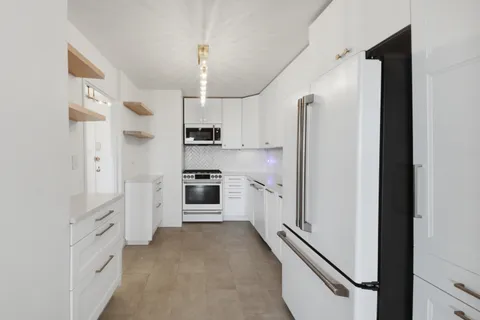 a kitchen with cabinets and refrigerator