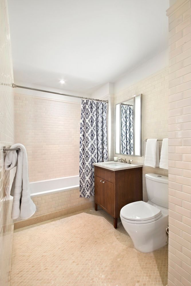 2150 Broadway, Unit 9E Manhattan, NY 10023 - Photo 9 of 14 a bathroom with a bathtub sink mirror vanity and a toilet