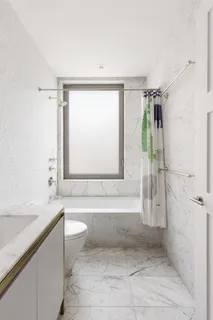 a bathroom with a granite countertop bathtub shower sink and toilet