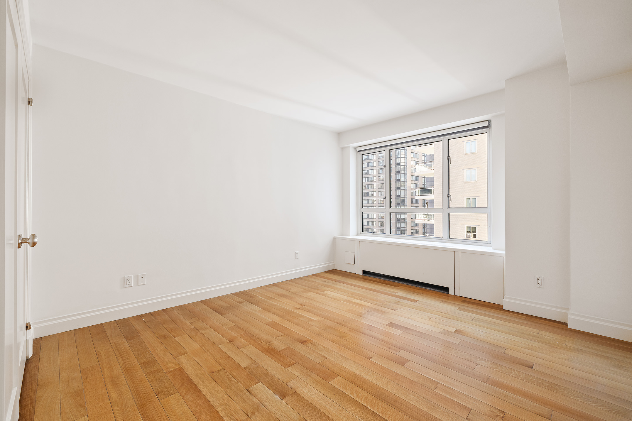 200 East 66th Street, Unit D1203 Manhattan, NY 10065 - Photo 11 of 24 an empty room with wooden floor and windows